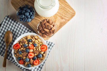 Healthy breakfast concept with oat flakes and fresh berries on rustic background. Food made of granola and muesli. Healthy banana smoothie with blackberries, honey and milk.