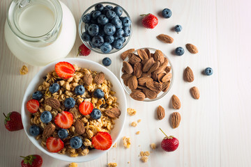 Healthy breakfast concept with oat flakes and fresh berries on rustic background. Food made of granola and muesli. Healthy banana smoothie with blackberries, honey and milk.