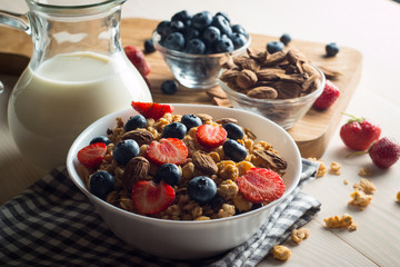Healthy breakfast concept with oat flakes and fresh berries on rustic background. Food made of granola and muesli. Healthy banana smoothie with blackberries, honey and milk.
