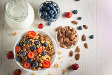 Healthy breakfast concept with oat flakes and fresh berries on rustic background. Food made of granola and muesli. Healthy banana smoothie with blackberries, honey and milk.