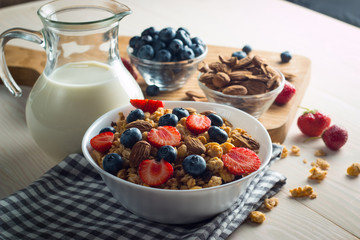 Healthy breakfast concept with oat flakes and fresh berries on rustic background. Food made of granola and muesli. Healthy banana smoothie with blackberries, honey and milk.