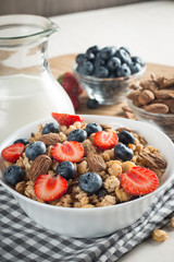 Healthy breakfast concept with oat flakes and fresh berries on rustic background. Food made of granola and muesli. Healthy banana smoothie with blackberries, honey and milk.