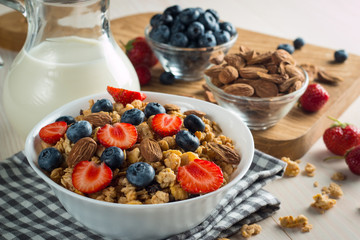 Healthy breakfast concept with oat flakes and fresh berries on rustic background. Food made of granola and muesli. Healthy banana smoothie with blackberries, honey and milk.