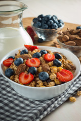 Healthy breakfast concept with oat flakes and fresh berries on rustic background. Food made of granola and muesli. Healthy banana smoothie with blackberries, honey and milk.