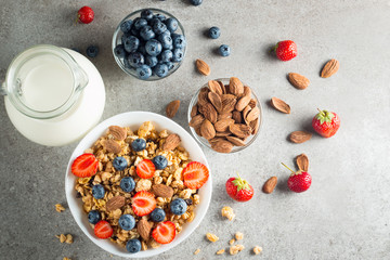 Healthy breakfast concept with oat flakes and fresh berries on rustic background. Food made of granola and muesli. Healthy banana smoothie with blackberries, honey and milk.
