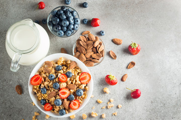 Healthy breakfast concept with oat flakes and fresh berries on rustic background. Food made of granola and muesli. Healthy banana smoothie with blackberries, honey and milk.