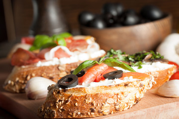 Italian tomato and cheese bruschetta. Tapas, antipasti with chopped vegetables, herbs and oil on grilled ciabatta and baguette bread.