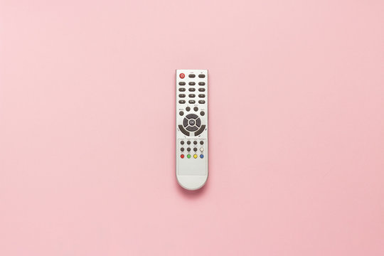 Gray Remote Control On A Pink Background. The Concept Of Television, Movies, TV Shows, Sports, Day And Night. Flat Lay, Top View.