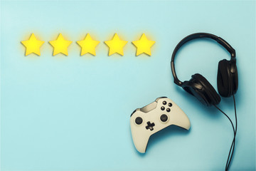 Gamepad and headphones on a blue background. Added five stars rating. Reputation. The concept of...
