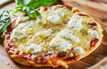 Pizza with Mozzarella cheese, Tomatoes, pepper, Spices and Fresh Basil. Italian pizza. Pizza Margherita or Margarita on wooden table background