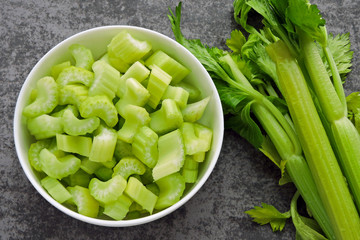 Chopped fresh celery stalks in a bowl. Top view.