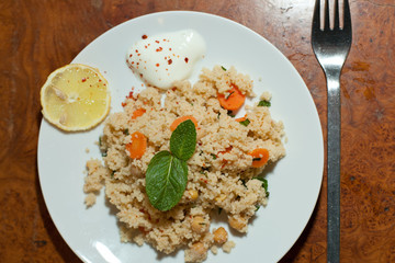 tasty Couscous dish with fresh vegetables, decoration and sauce