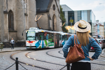 Woman tourist is looking at passing tram in ancient city Olomouc, Czech Republic, Europe