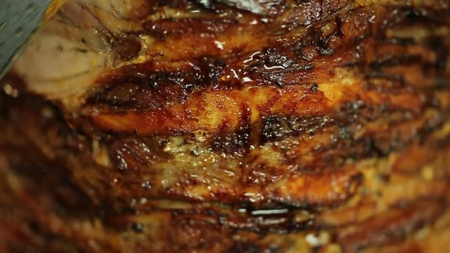 A cook cuts meat to make shawarma, gyros, doner kebab. Cooking meat on a skewer