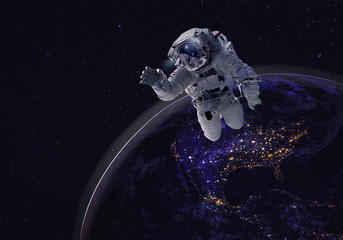 Astronaut in the backdrop of the planet earth. Elements of this image furnished by NASA.