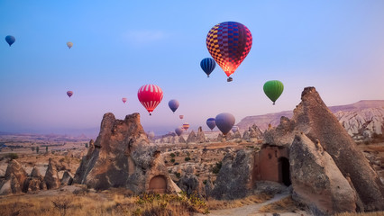 Beautiful hot air balloons flying over Cappadocia landscape at sunrise