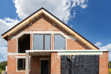 Modern brick house under construction against blue sky