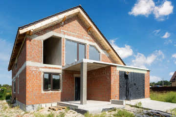Unfinished family house built from red brick