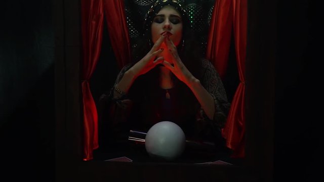 Young Fortune Teller Woman Sitting In A Small Booth