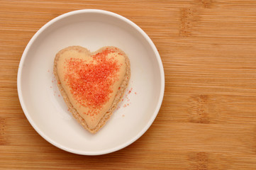 Naklejka na ściany i meble Heart-shaped macaroons in a white plate on wooden background.