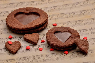Chocolate chip cookies in the shape of a heart with toffee, on a decorative background musical notes.