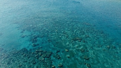 stunning aerial drone image of a a small fishing boat entering an a sea ocean anchorage in a...