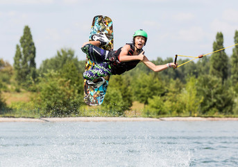 Wakeboarder im Flug zeigt Daumen hoch