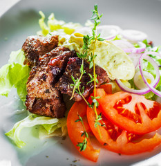fried beef piece fillet with vegetables salad on white plate