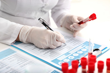 Woman working with blood samples in laboratory, closeup