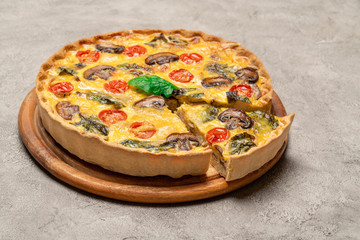 Traditional french Baked homemade quiche pie on wooden cutting board