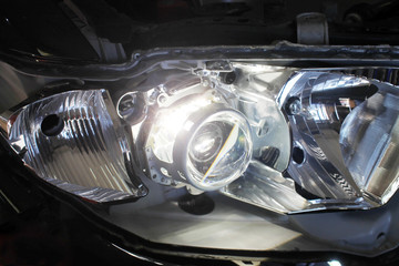 Macro view of repairing, installation and tuning headlight of modern automobile and car projector...