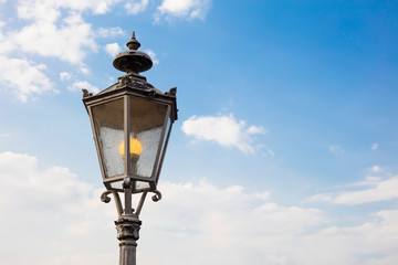 Fototapeta na wymiar Detail of german streetlamp with sky in background and copyspace