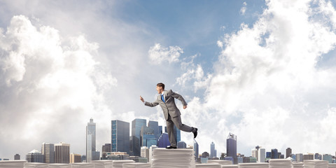 Precise businessman in suit running with phone.