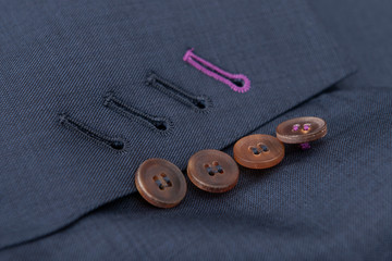 Detalle costura textil, botones chaqueta