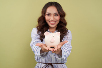 Fototapeta na wymiar Young beautiful woman standing with piggy bank (money box), isolated on white background