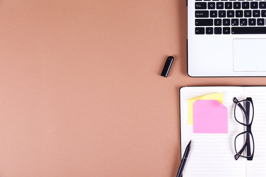 College student desk concept. Top view of a workspace with black and white laptop computer keyboard, school supplies, blank notebook for notes. Close up, copy space, background, flat lay.