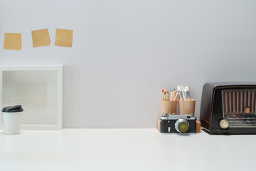 Fototapeta premium Mockup Blank poster, books, vintage radio and vintage camera on workspace desk