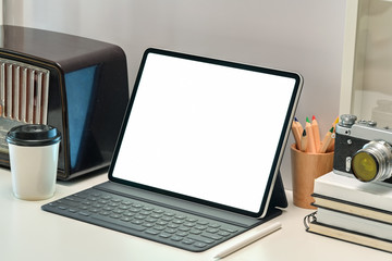 Creative workspace desk with vintage camera, radio and blank screen tablet.