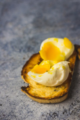 Crispy baguette toasts soft boiled egg and light blue rustic background.