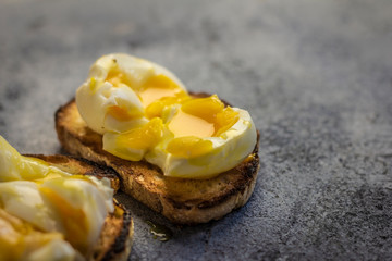 Crispy baguette toasts soft boiled egg and light blue rustic background.