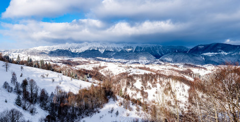 Brasov - Romania, Rucar - Bran snowy picturesque hills on a sunny cold December. Wide panorama of the Carpathian mountains.