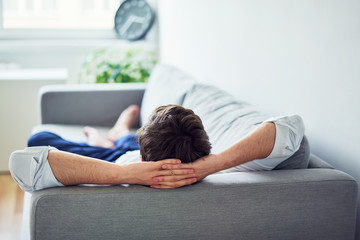 Young man relaxing on sofa after work