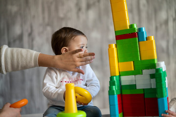 Fototapeta na wymiar Happy baby playing with toy blocks.
