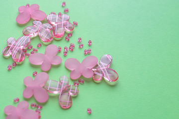 Oval beads and butterfly beads on a gren background. Use as a background, cards. Handicraft and hobby accessories