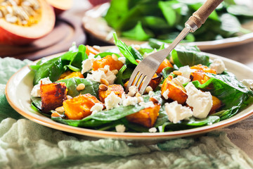 Roasted pumpkin salad with spinach and nuts