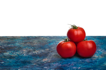 Pomidory leżące na blacie i miejsce na tekst. Trzy dojrzałe warzywa. Piramidka z pomidorów.  