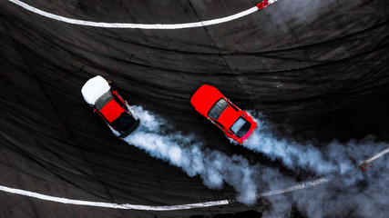 Car drift battle on abstract black texture and background tire skid mark, Two car drifting battle on race track with smoke, Aerial view automobile and automotive. - obrazy, fototapety, plakaty