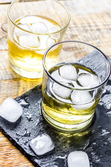 glass of whiskey on wooden background