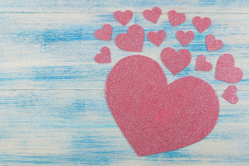 Pink shiny heart on a blue wooden background. view from above. place for text. Valentine's Day