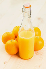 Bottle of freshly pressed orange juice with oranges